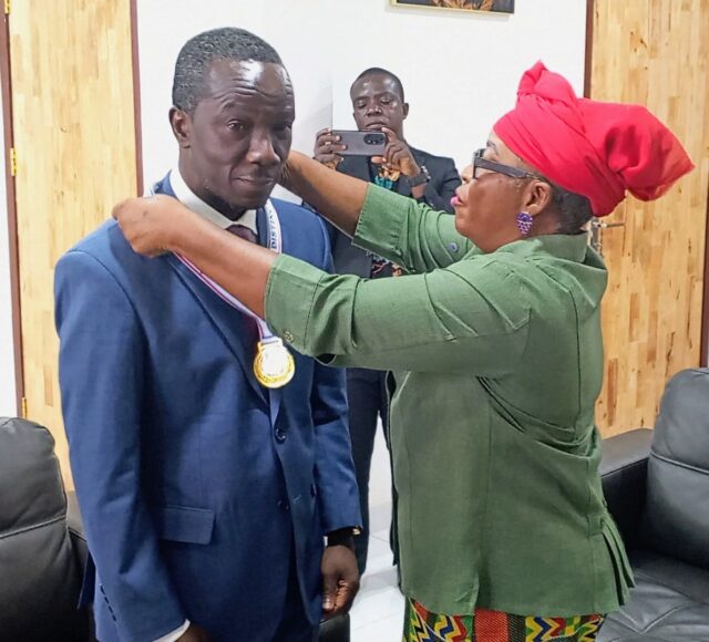 Paye being honored by a Representative of the Liberia Council of Churches